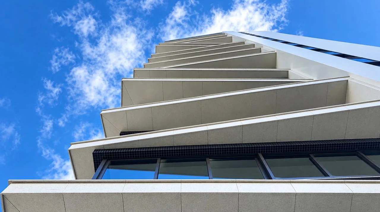 Fachada do Residencial Marais — sacadas anguladas da torre premiada vistas de baixo contra o céu